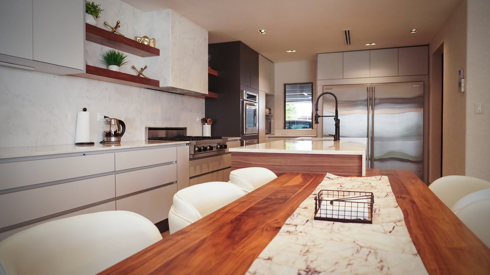 Cocina con isla de madera, mármol Calacatta y refrigerador integrado, proyecto Berenice